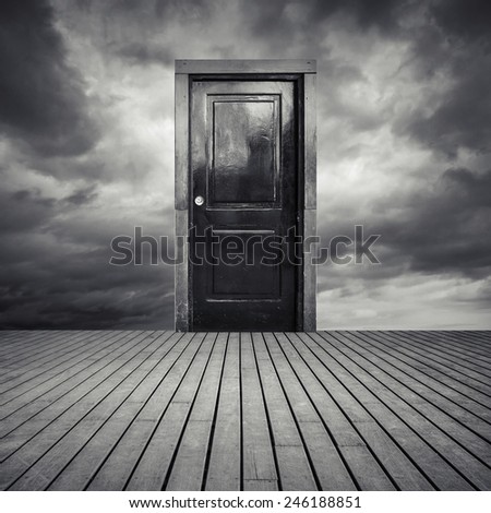 Abstract interior concept with old black door, wooden floor and dramatic sky