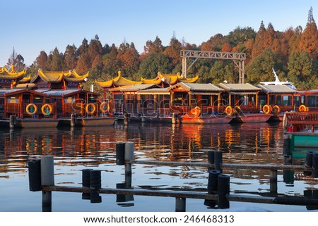 Traditional Chinese wooden recreation boats are moored on the West Lake coast. Famous park in Hangzhou city, China