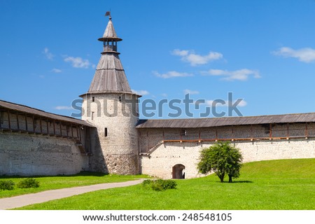 Classical Russian ancient architecture. Stone tower and walls with wooden roofs of old fortress. Kremlin of Pskov, Russia