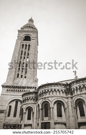Belltower of Sacre Coeur Basilica, large medieval cathedral, Basilica of Sacred Heart, popular landmark of Paris, France. Sepia toned photo