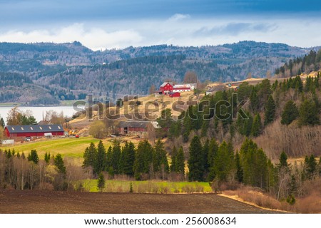 Rural Norwegian landscape with red wooden houses on hills