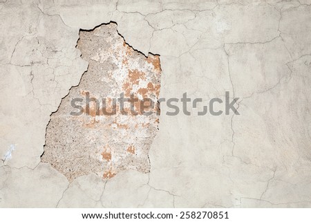 Old weathered concrete wall with damages and cracks on gray stucco, background texture