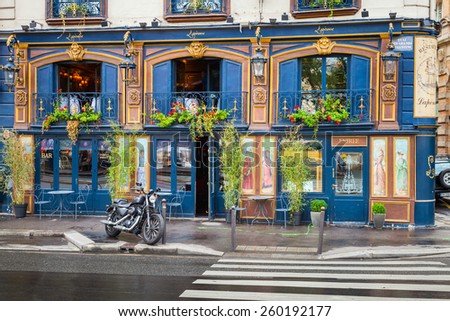 Paris, France - August 07, 2014: Black motorcycle stands parked near blue bar facade on the Quai Des Grands Augustins