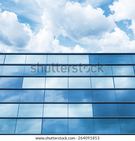 Modern office facade perspective. Blue mirrored glass and cloudy sky