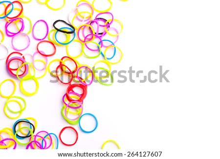 Small round colorful rubber bands for making rainbow loom bracelets isolated on white