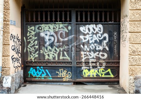 Saint-Petersburg, Russia - April 3, 2015: Old black locked gate with chaotic graffiti pattern. Vasilievsky island, Central old part of St. Petersburg city