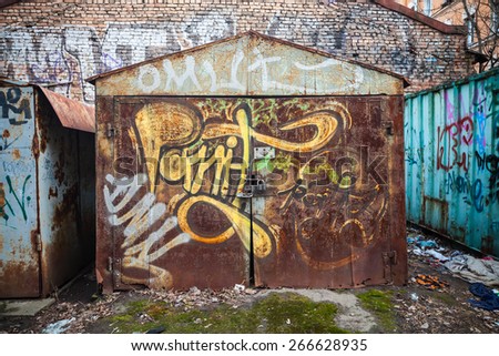 Saint-Petersburg, Russia - April 3, 2015: Old rusted garages with grungy graffiti pattern. Vasilievsky island, Central old part of St. Petersburg city