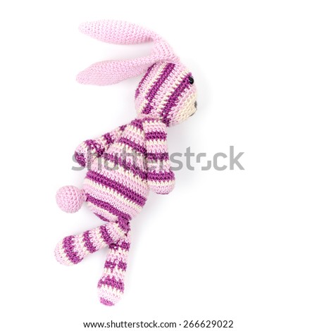 Knitted rabbit toy is running fast, closeup photo isolated on white background
