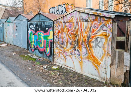 Saint-Petersburg, Russia - April 3, 2015: Old rusted locked abandoned garages with colorful grungy graffiti. Vasilievsky island, Central old part of St. Petersburg city