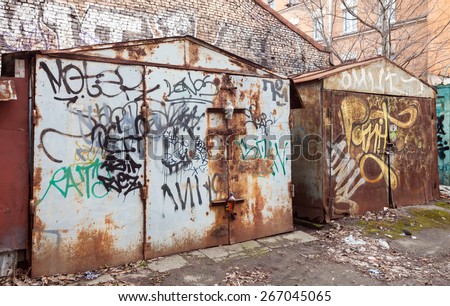 Saint-Petersburg, Russia - April 3, 2015: Two old rusted locked garages with grungy graffiti. Vasilievsky island, Central old part of St. Petersburg city