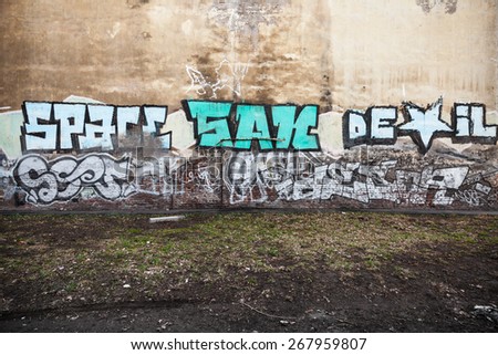 Saint-Petersburg, Russia - April 3, 2015: Graffiti fragment with colorful text on old yellow wall. Vasilievsky island, Central part of St. Petersburg city
