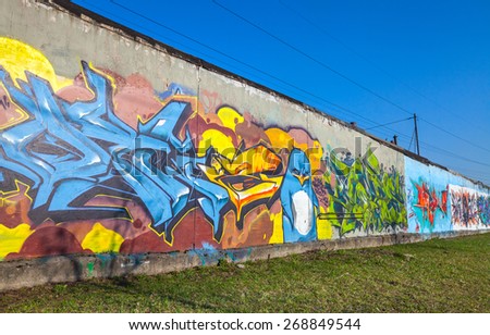 Saint-Petersburg, Russia - April 6, 2015: Colorful graffiti with chaotic text elements over old gray concrete garage walls