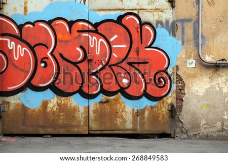 Saint-Petersburg, Russia - April 6, 2015: Colorful graffiti with chaotic text elements over old rusted metal gate