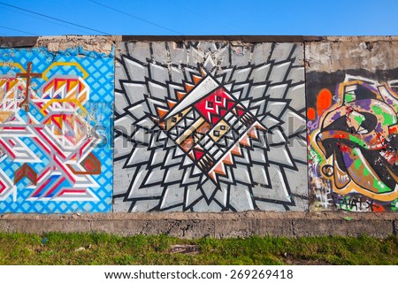 Saint-Petersburg, Russia - April 6, 2015: Colorful graffiti on old gray concrete garage walls