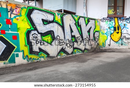 Saint-Petersburg, Russia - April 7, 2015: Colorful chaotic graffiti text patterns painted over  old concrete fence