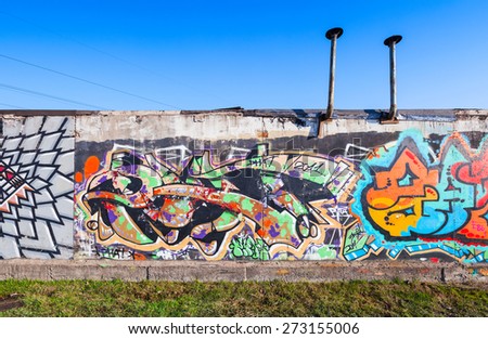 Saint-Petersburg, Russia - April 6, 2015: Colorful graffiti painted on old gray concrete garage walls