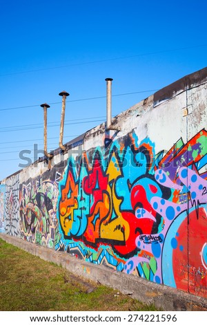 Saint-Petersburg, Russia - April 6, 2015: Colorful abstract graffiti painted on old gray concrete garage walls. Vertical photo