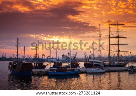 Sailing ships and yachts stand moored in Varna harbor at the sunset. Black Sea coast, Bulgaria