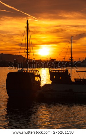 Recreation sailing ships stand moored in Varna port at the sunset. Bulgaria, vertical photo