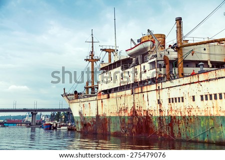 Old abandoned rusted ship stands moored in Varna port, Bulgaria. Vintage stylized photo with tonal correction filter