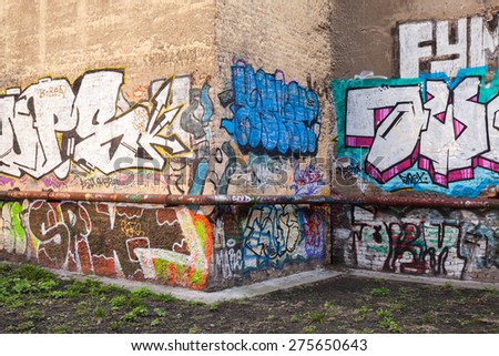 Saint-Petersburg, Russia - May 6, 2015: Abandoned urban courtyard with colorful abstract graffiti text patterns on old damaged walls. Vasilievsky island, Central part of St. Petersburg