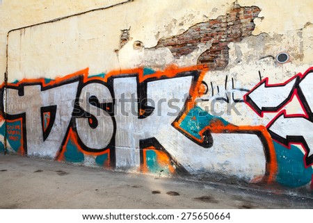 Saint-Petersburg, Russia - May 6, 2015: Abandoned urban courtyard with colorful abstract graffiti text on old damaged wall. Vasilievsky island, Central part of St. Petersburg