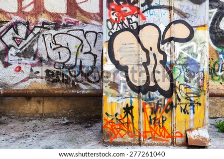 Saint-Petersburg, Russia - May 6, 2015: Abandoned urban courtyard interior with colorful abstract graffiti text on old damaged walls. Vasilievsky island, St. Petersburg