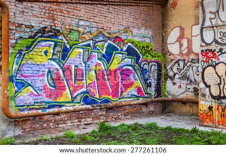 Saint-Petersburg, Russia - May 6, 2015: Abandoned urban courtyard with colorful abstract graffiti text pattern on old brick wall. Vasilievsky island, St. Petersburg city