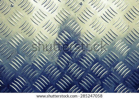 Blue shining metal floor surface with industrial diamond plate relief pattern, vintage tonal correction filter, old style instagram effect