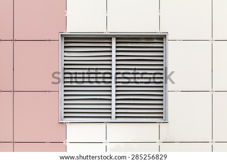 Gray ventilation grille on the window, modern industrial building facade fragment