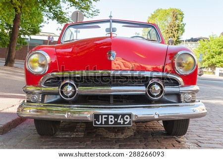 Helsinki, Finland - June 13, 2015: Old red Ford Custom Deluxe Tudor car is parked on the roadside. 1951 year modification with convertible roof, closeup front view