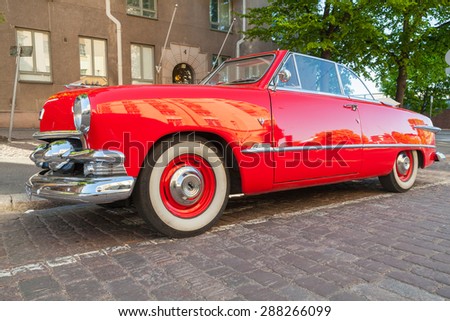 Helsinki, Finland - June 13, 2015: Old red Ford Custom Deluxe Tudor car is parked on the roadside. 1951 year modification with convertible roof