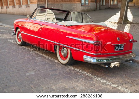 Helsinki, Finland - June 13, 2015: Old red Ford Custom Deluxe Tudor car is parked on the roadside. 1951 year modification with convertible roof, back view