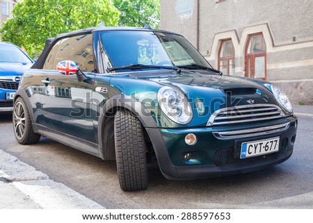 Helsinki, Finland - June 13, 2015: shining dark green metallic MINI Cooper S Convertible car is parked on the road side in the city