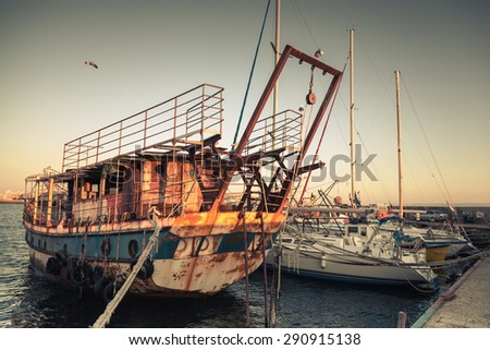 Old rusted pleasure boat is moored in Nesebar, ancient historical town, Bulgaria. Vintage retro stylized photo with tonal correction filter, instagram style
