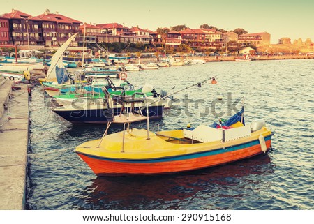 Small wooden boats in Nesebar, ancient historical town, Black Sea coast, Bulgaria. Vintage retro stylized photo with tonal correction filter, instagram style
