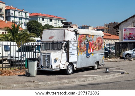 Ajaccio, France - June 30, 2015: Old white Citroen H Van, light truck converted to catering trailer with colorful advertising graffiti  and a menu