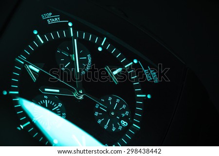 Luxury mens Chronograph Watch, clock deal with blue green illumination. Close-up blue toned studio photo with selective focus