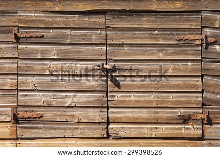Old rural brown wooden gate with padlock, background photo texture