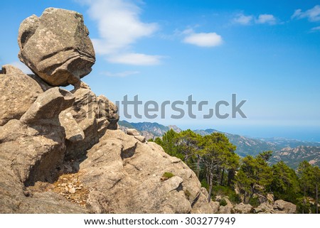 Big round stone lays on top of a coastal rock, Corsica island, Ospedale region