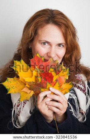 Portrait of beautiful Young Caucasian woman in traditional Russian neck scarf with colorful autumn maple leaves