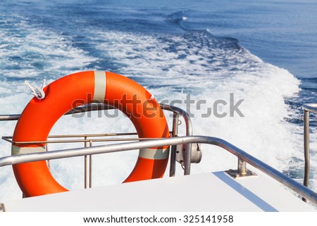 Red lifebuoy hanging on stern of fast safety rescue boat