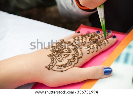 Saint-Petersburg, Russia - July 19, 2015: Henna paste or mehndi application on woman hand, traditional Indian natural skin decoration