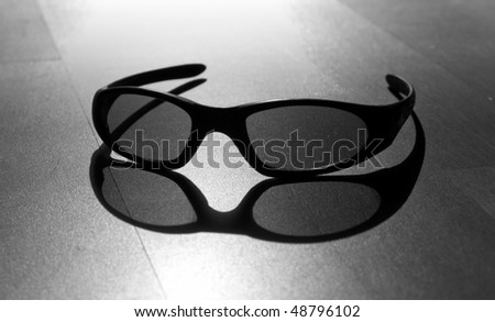 Monochrome photo of black modern sun glasses with back sun light and shadow