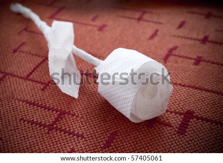 Rose made of paper napkin on the table in a restaurant.