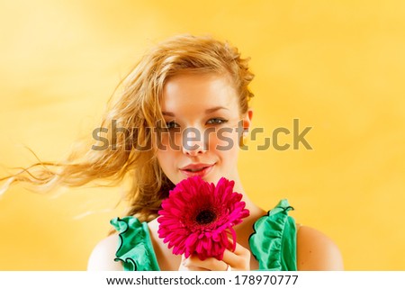 Portrait of a girl with a flower on a yellow background