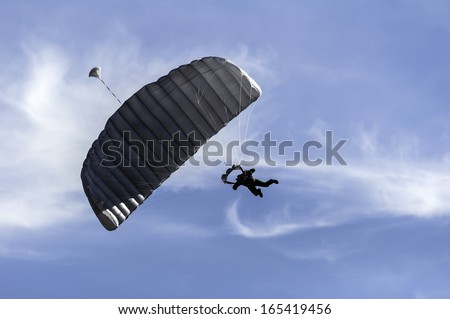 Skydiver maneuvers at low altitude as he approaches the landing zone.