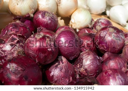red ad white onions on flea market shelf display