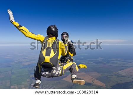 Two girls holding hands parachutist.