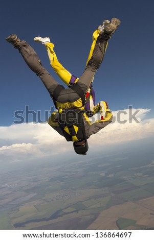 A girl and a guy skydivers perform pieces in free fall.